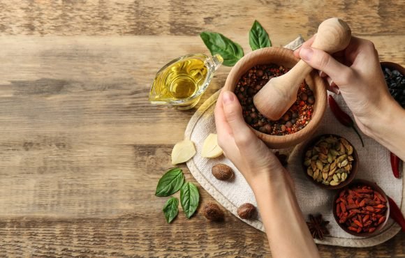 Female hands grinding spices in mortar